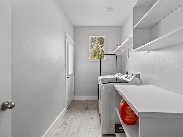 washroom featuring independent washer and dryer and light hardwood / wood-style flooring