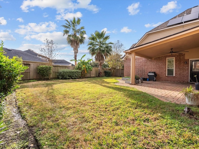 view of yard with ceiling fan and a patio