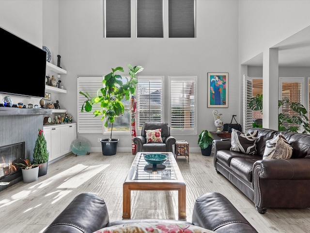 living room featuring a towering ceiling and light wood-type flooring