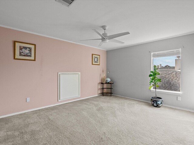 carpeted spare room featuring ceiling fan and crown molding