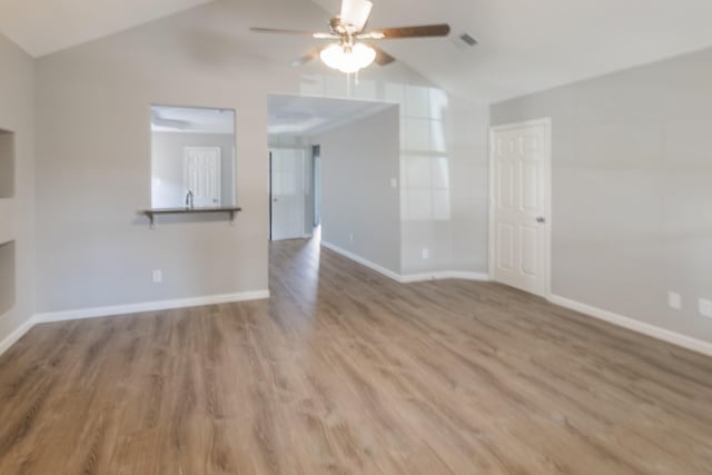 unfurnished living room with ceiling fan, wood-type flooring, and vaulted ceiling