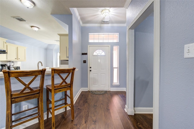 entrance foyer with crown molding and dark hardwood / wood-style floors