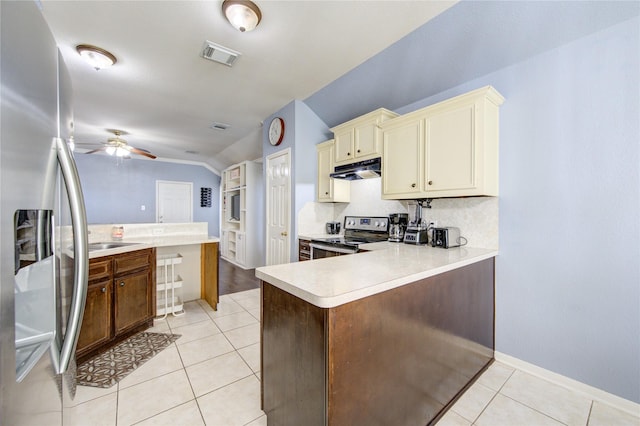 kitchen featuring kitchen peninsula, appliances with stainless steel finishes, vaulted ceiling, ceiling fan, and cream cabinets