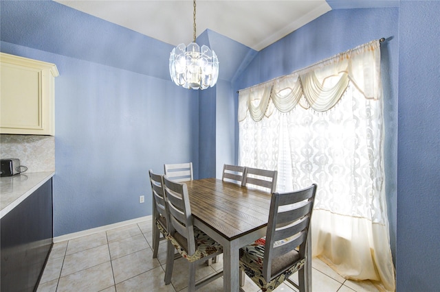 tiled dining space featuring a chandelier and lofted ceiling