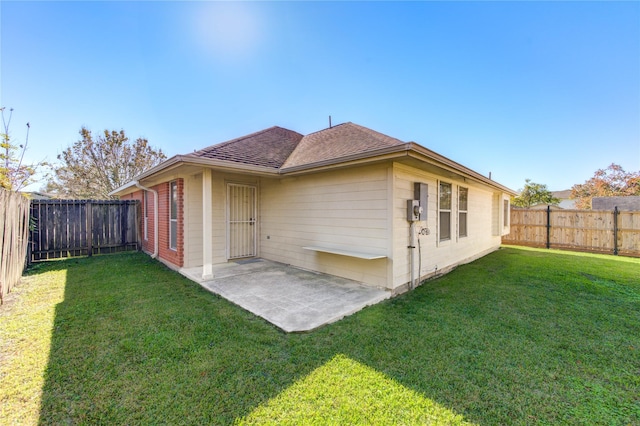 back of property with a patio area and a yard