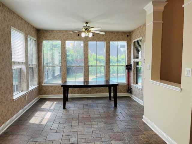 unfurnished sunroom with ceiling fan and plenty of natural light