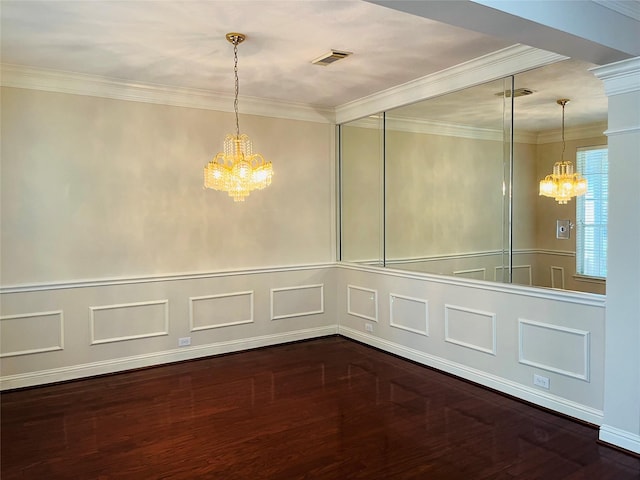 spare room with crown molding, a chandelier, and hardwood / wood-style flooring