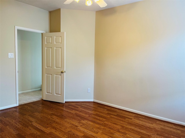 spare room featuring ceiling fan and dark wood-type flooring