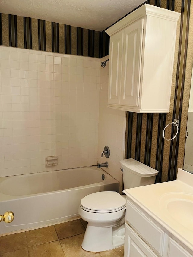 full bathroom with vanity, a textured ceiling, washtub / shower combination, tile patterned flooring, and toilet