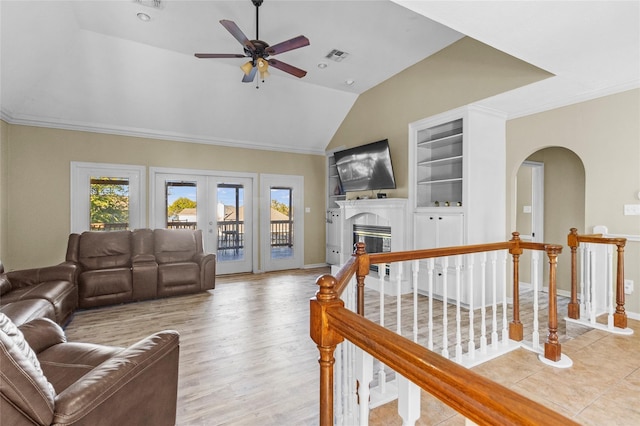 living room featuring ceiling fan, french doors, and built in shelves