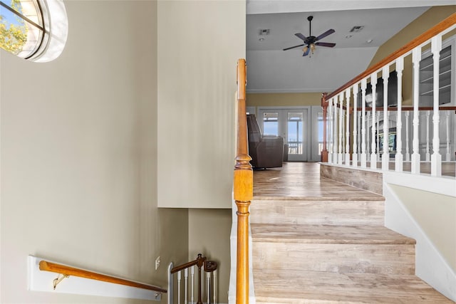 stairs featuring ceiling fan and french doors