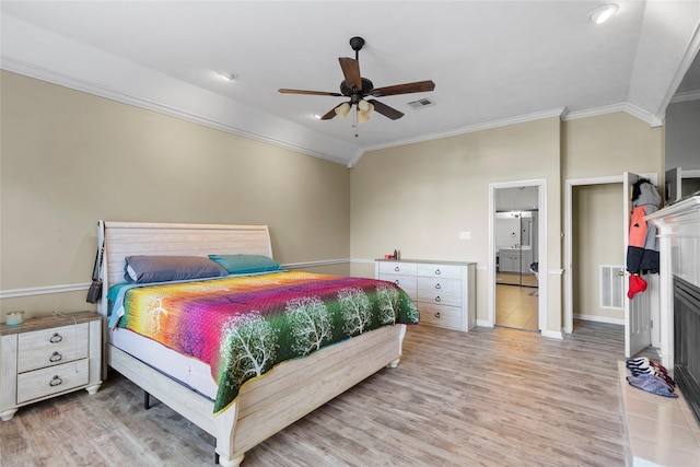 bedroom with ceiling fan, vaulted ceiling, crown molding, light hardwood / wood-style flooring, and connected bathroom