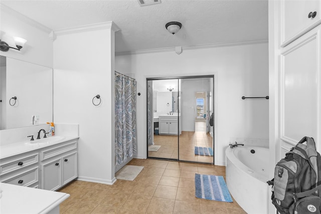 bathroom with a textured ceiling, tile patterned flooring, vanity, crown molding, and separate shower and tub