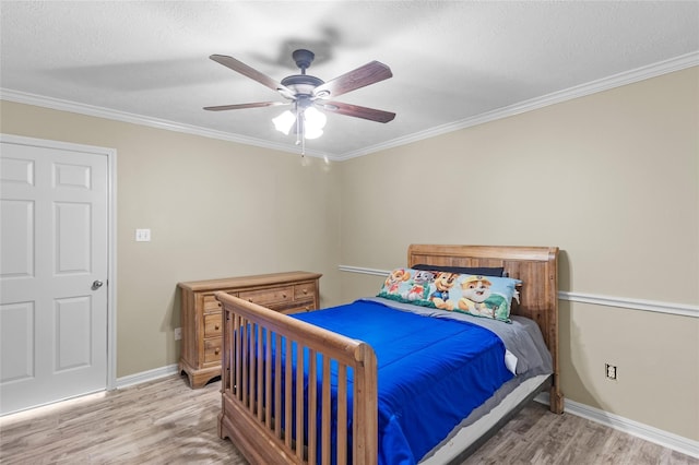 bedroom with a textured ceiling, ceiling fan, ornamental molding, and hardwood / wood-style flooring