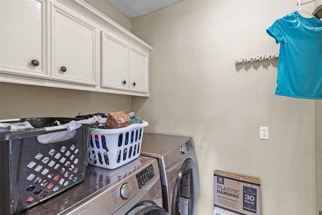 washroom with cabinets and washing machine and clothes dryer