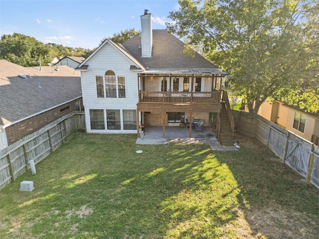 rear view of house with a wooden deck, a patio area, and a yard