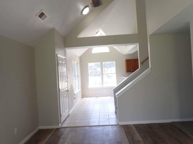 entrance foyer with vaulted ceiling and light hardwood / wood-style floors