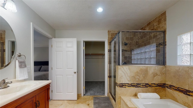 bathroom with tile patterned floors, vanity, a textured ceiling, and shower with separate bathtub