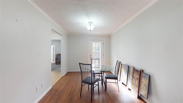 dining room featuring hardwood / wood-style flooring, crown molding, and a textured ceiling