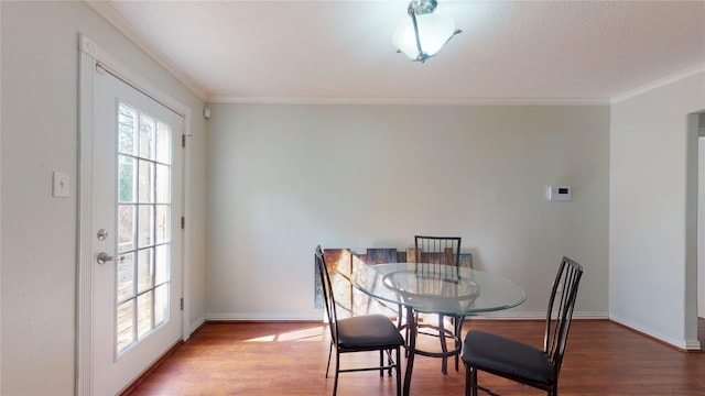 dining space with wood-type flooring and ornamental molding