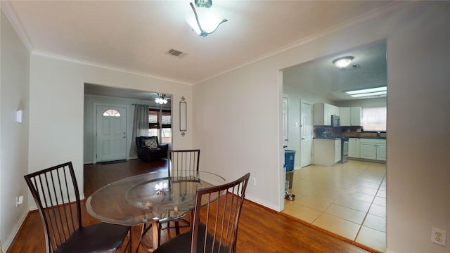 dining space featuring crown molding and light hardwood / wood-style floors