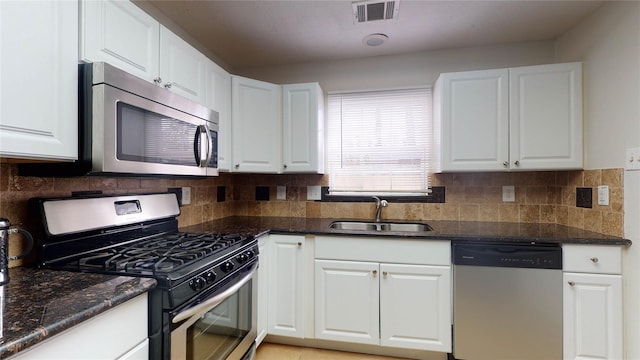 kitchen with appliances with stainless steel finishes, white cabinetry, and sink