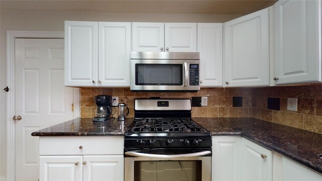 kitchen with tasteful backsplash, dark stone counters, white cabinets, and stainless steel appliances