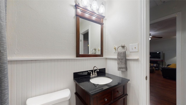 bathroom with hardwood / wood-style flooring, ceiling fan, toilet, and vanity