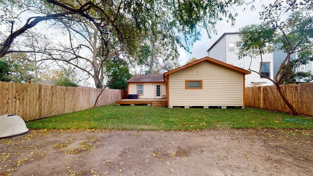 back of property with a lawn and a deck