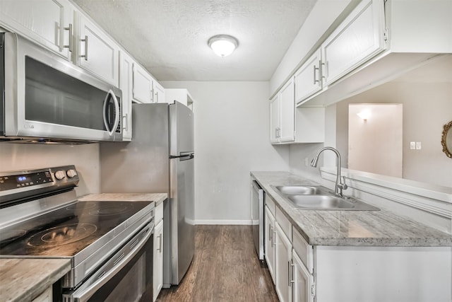 kitchen with dark hardwood / wood-style flooring, white cabinetry, sink, and appliances with stainless steel finishes