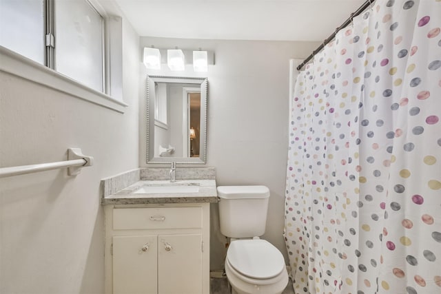 bathroom featuring toilet, vanity, and walk in shower