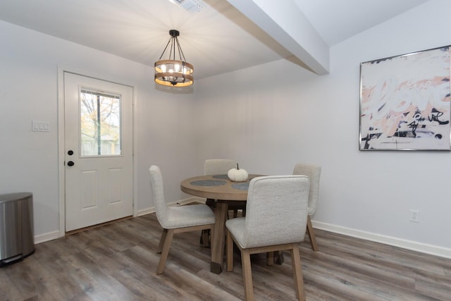 dining area featuring a chandelier, dark hardwood / wood-style flooring, and vaulted ceiling