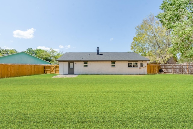 rear view of house featuring a lawn