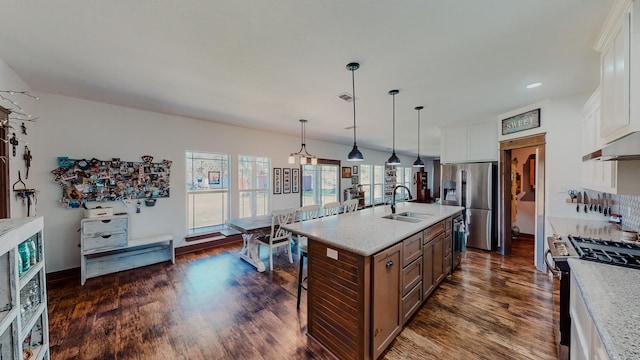 kitchen with a kitchen island with sink, sink, dark hardwood / wood-style floors, white cabinetry, and stainless steel appliances