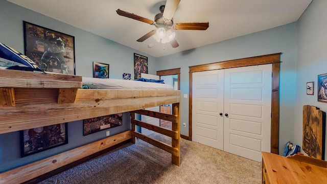 carpeted bedroom with ceiling fan and a closet