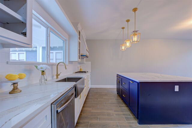 kitchen with stainless steel dishwasher, decorative light fixtures, blue cabinets, and white cabinetry