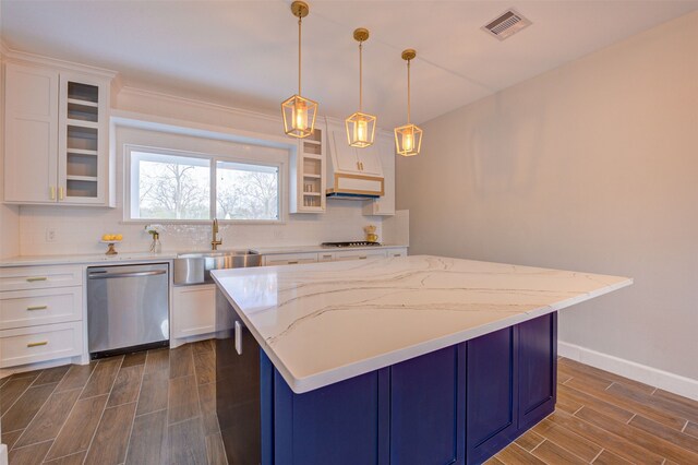 kitchen featuring stainless steel appliances, white cabinetry, and decorative light fixtures