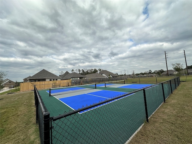 view of sport court featuring a lawn