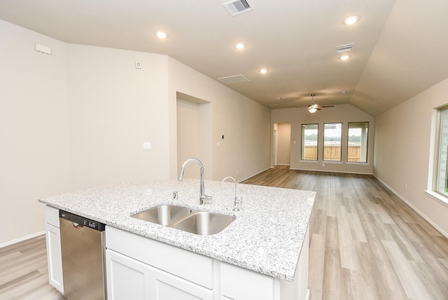 kitchen featuring dishwasher, a center island with sink, sink, vaulted ceiling, and white cabinetry