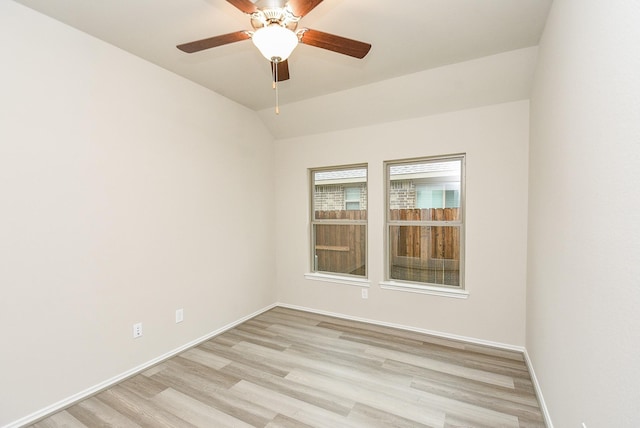 spare room with ceiling fan, light wood-type flooring, and vaulted ceiling