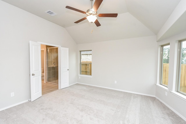 carpeted spare room with a wealth of natural light, lofted ceiling, and ceiling fan