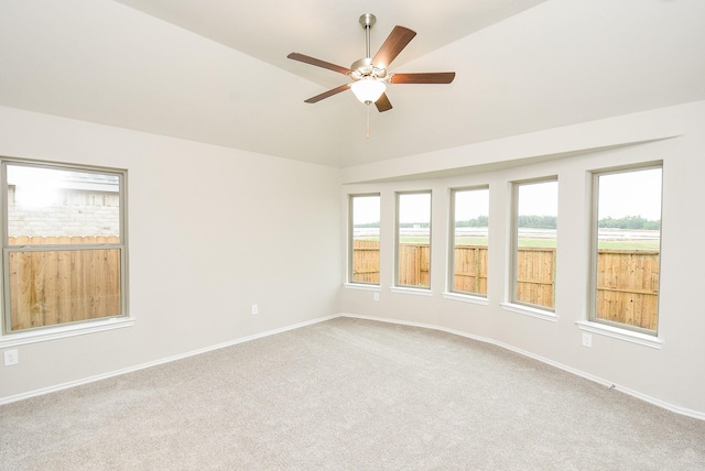 carpeted spare room featuring ceiling fan and lofted ceiling