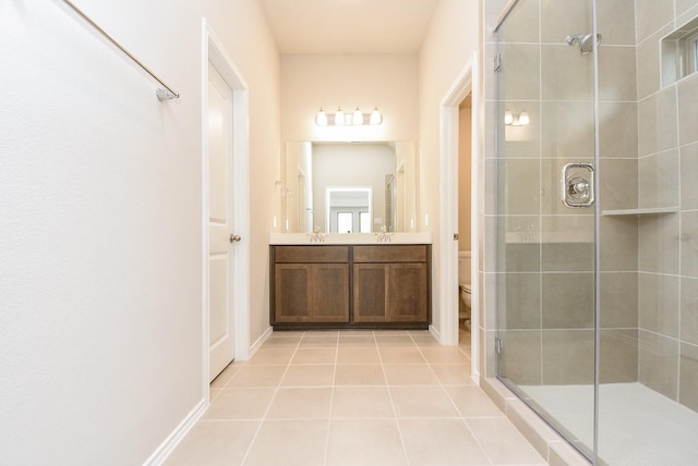 bathroom featuring tile patterned flooring, vanity, toilet, and a shower with shower door