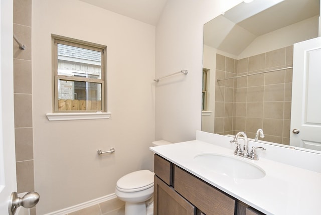 bathroom featuring tile patterned flooring, vanity, toilet, and lofted ceiling