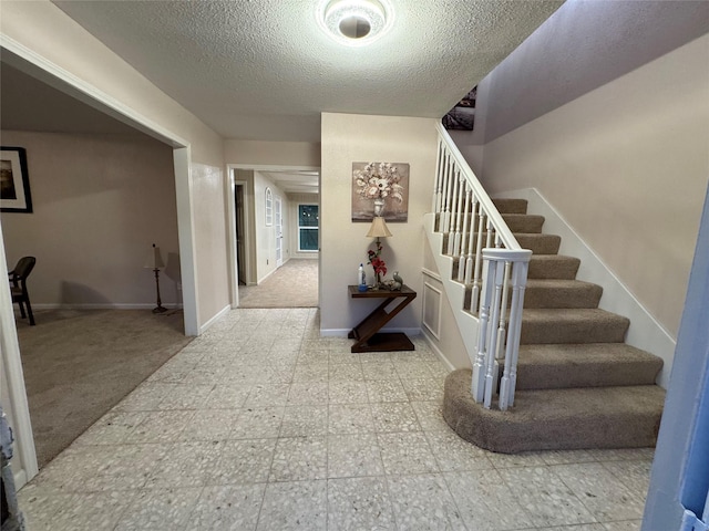 interior space featuring carpet flooring and a textured ceiling