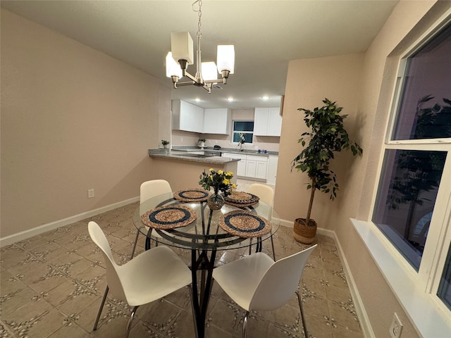 dining room featuring sink and a notable chandelier