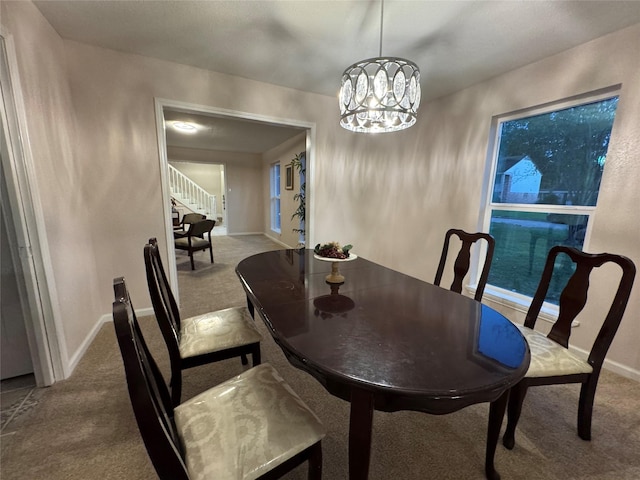 dining space featuring carpet flooring and an inviting chandelier