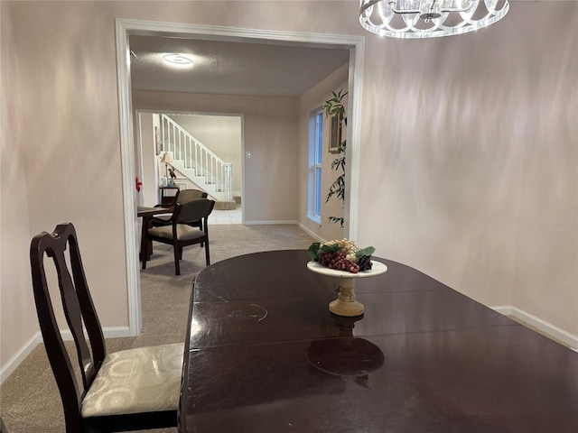 carpeted dining room with an inviting chandelier