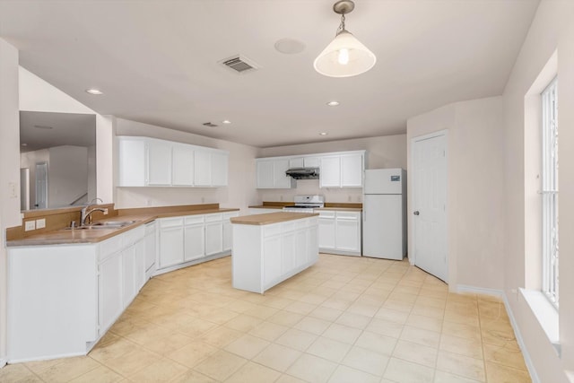 kitchen with a center island, white appliances, white cabinets, sink, and decorative light fixtures