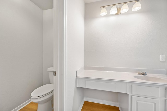 bathroom with vanity, toilet, and wood-type flooring